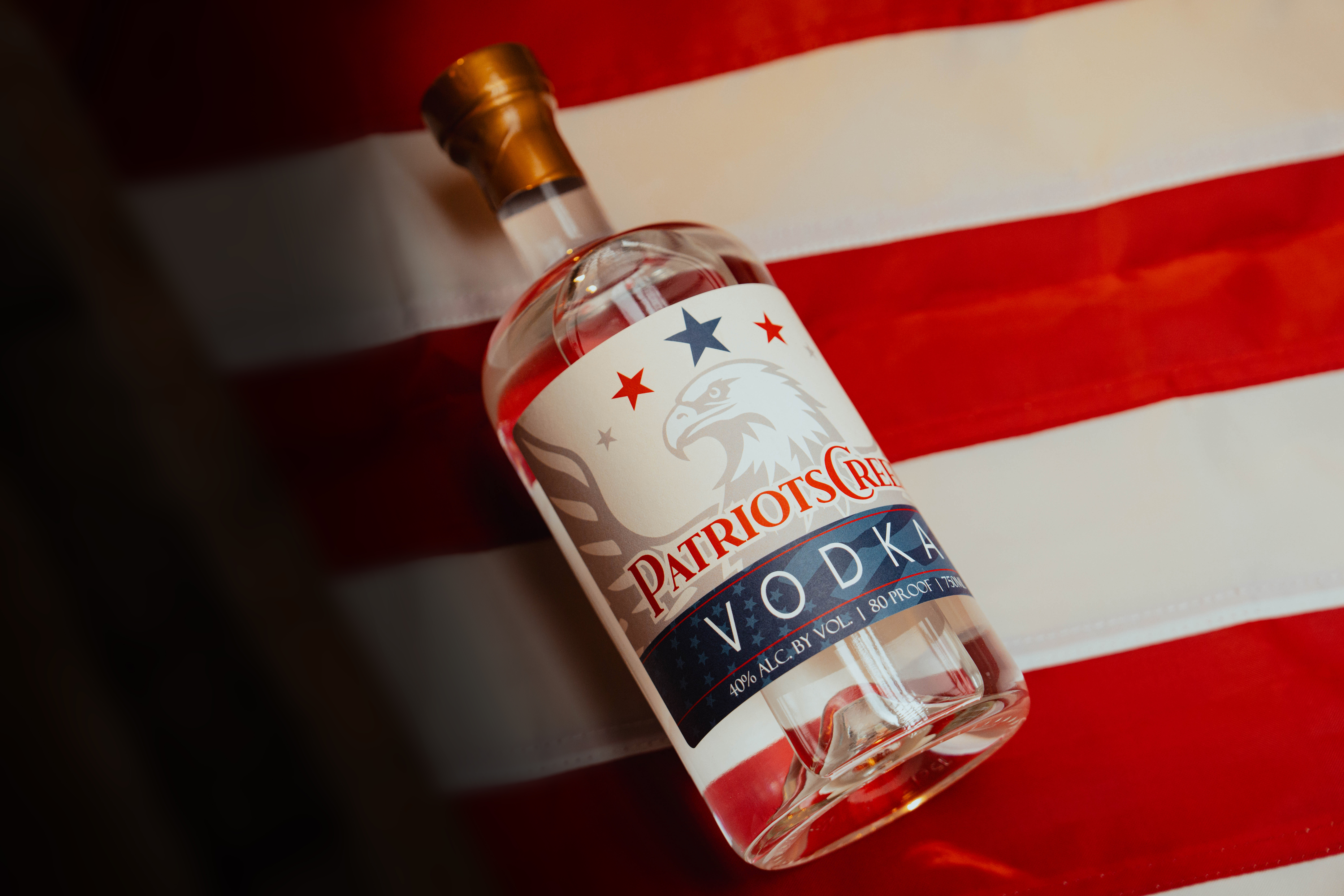 Patriot's Creed Vodka Bottle - Professionally photographed. Sitting atop an American flag.